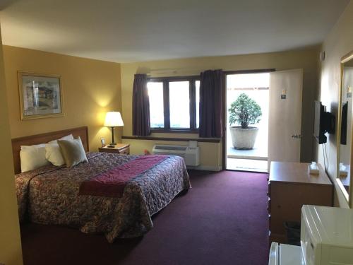 a hotel room with a bed and a window at Midway Inn & Suites in Oak Lawn