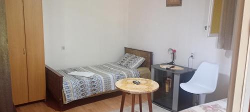 a small bedroom with a bed and a table at Apartman Laura 3 in Kamenari