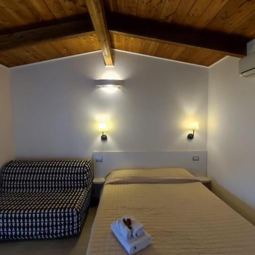 a bedroom with two beds and lights on the wall at Residence Arco delle Rose in Agropoli