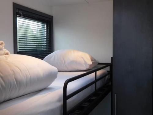 a bed with two pillows on it with a window at Boot zonder naam in Volendam