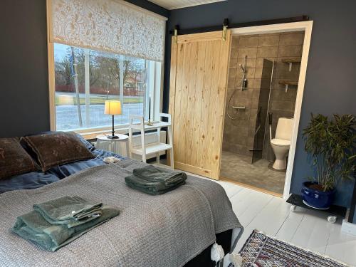 ein Schlafzimmer mit Bett und ein Badezimmer mit Dusche in der Unterkunft Matmalmen E&A in Pargas
