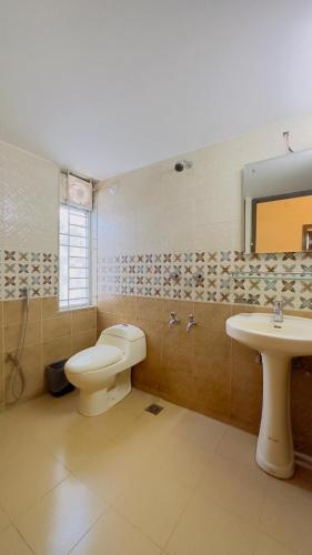 a bathroom with a toilet and a sink at Hotel The Grand Hyatt Dhaka in Dhaka