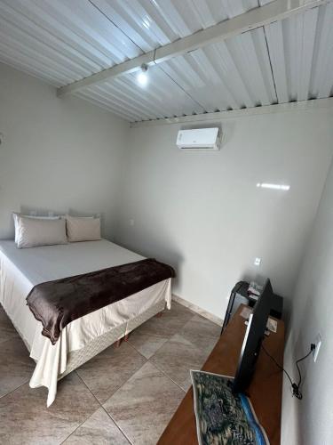 a bedroom with a bed in a white room at Cerrado da Canastra Chalé Quartinho simples in São Roque de Minas