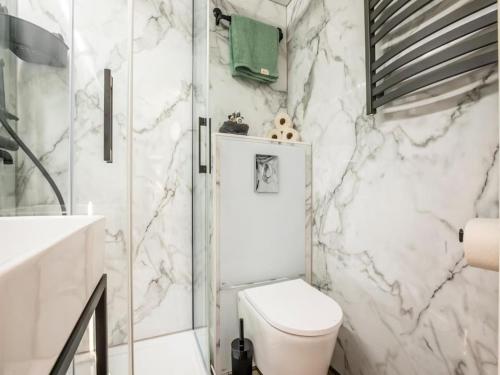 a white bathroom with a toilet and a shower at Marina Sunrise in Volendam