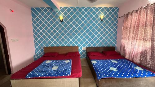 two beds in a room with blue and white walls at RR palace in Pachmarhī