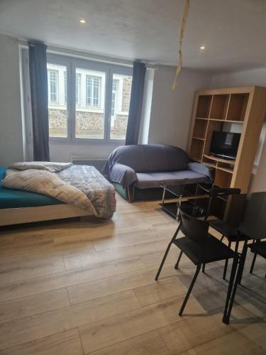 a bedroom with a bed and a desk and chairs at Studio la Romagne in La Romagne