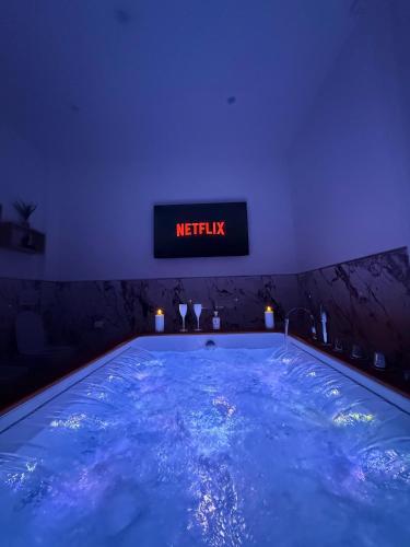 a large swimming pool in a room with a night sign at Villa La Torre in San Giuliano Terme
