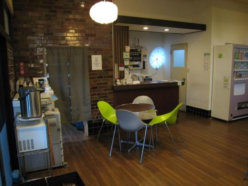 a room with a table and chairs and a counter at Hotel Eco Dogo in Matsuyama