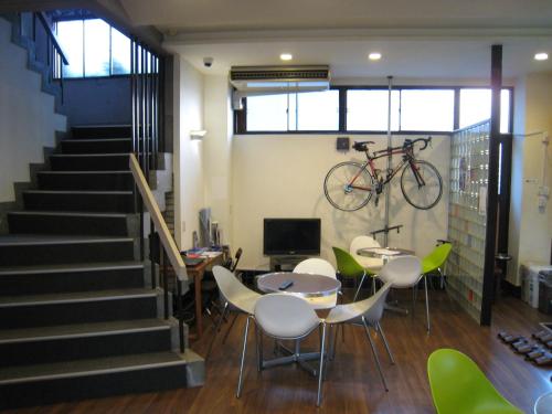 a room with a table and a bike on the wall at Hotel Eco Dogo in Matsuyama