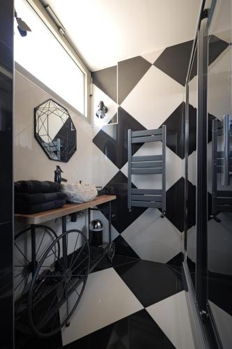 a bathroom with a black and white checkered floor at Maison Les Étoiles chambres d'hôtes de charme avec jardin paisible et petit déjeuner à Tonnerre in Tonnerre