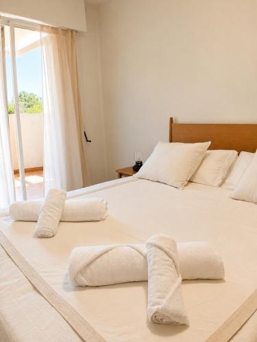 two beds in a bedroom with white sheets at Airtegal Dunas de Cedeira in Cedeira