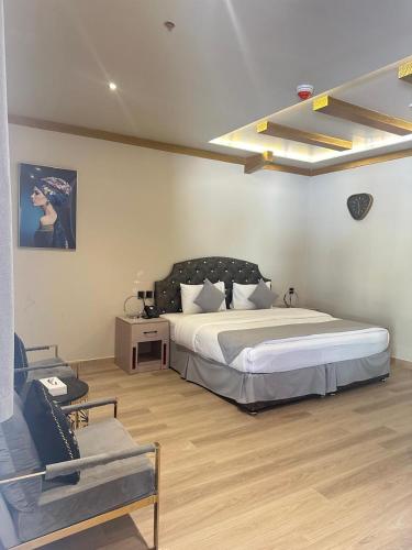 a bedroom with a large bed and a chair at Daraysh Hotel 