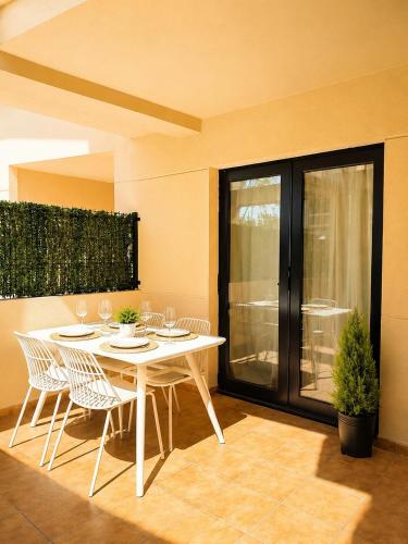 a dining room with a white table and chairs at Airtegal Dunas de Cedeira in Cedeira