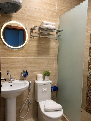 a bathroom with a toilet and a sink and a mirror at Sun Hotel in Cairo