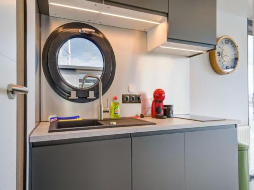 a kitchen with a sink and a round window at Le Belle Vie in Volendam