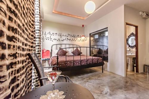 a room with a bed and a table with a wine glass at Green Gallery Beach Boutique Hotel in Hua Hin