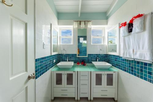 a bathroom with two sinks and blue tiles at Antigua Village Beach Resort in Saint Johnʼs