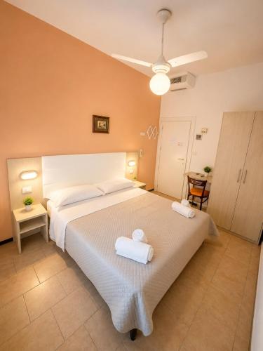 a bedroom with a large bed with two towels on it at Hotel Malibù in Rimini