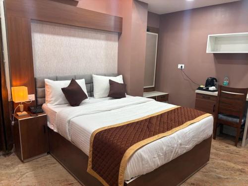 a bedroom with a large bed and a desk at Raj Hussain Land Mark Hotel in Mayiladuthurai
