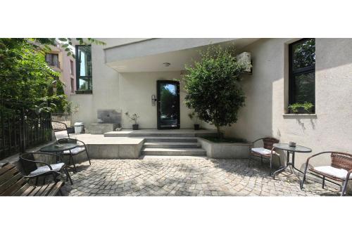 a courtyard with chairs and tables and a building at Guesthouse Odesos in Sozopol