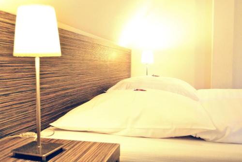 a bedroom with a bed with a headboard and a lamp at Hotel Dietrichsdorfer Hof in Kiel