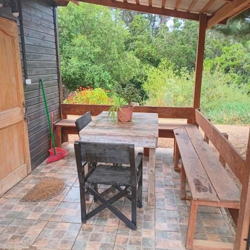 a wooden table and chairs on a patio at Mi Guarida in El Tabo