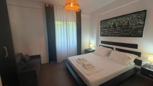 a bedroom with a bed with two towels on it at SoleMar Suites in Vlorë