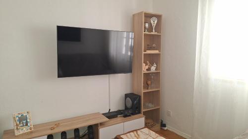 a flat screen tv hanging on a wall at Pescadores GuestHouse in Costa da Caparica