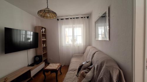 a living room with a couch and a tv at Pescadores GuestHouse in Costa da Caparica