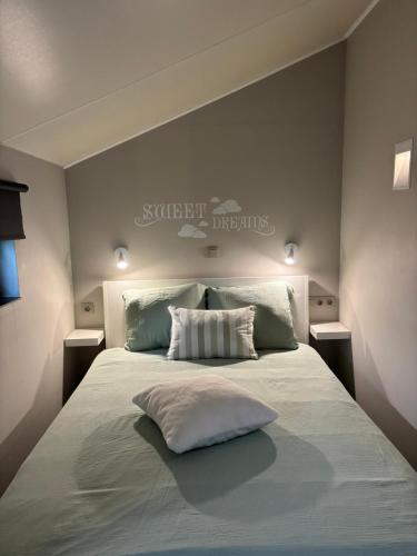 a bedroom with a large white bed with two pillows at Hoveke Paddebroek in Alveringem