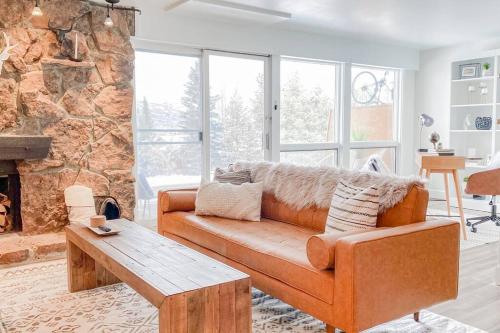 a living room with a couch and a fireplace at Modern Mountainside Chalet in Steamboat Springs