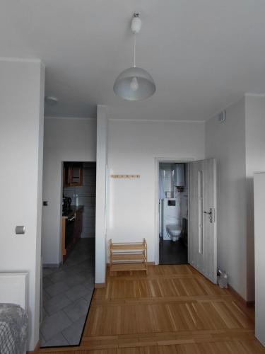 a living room with white walls and wooden floors at Kawalerka nad Odrą in Brzeg