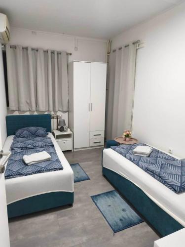 a bedroom with two beds with blue and white at Markaz Apartman Bihac in Bihać