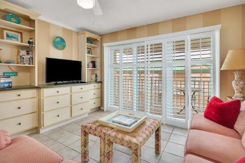 a living room with a couch and a tv at Beach Club 436 in Saint Simons Island
