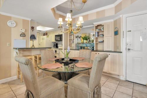 a dining room with a glass table and chairs at Beach Club 436 in Saint Simons Island