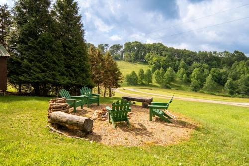 a group of green benches sitting in a field at Serenity Summit in Banner Elk