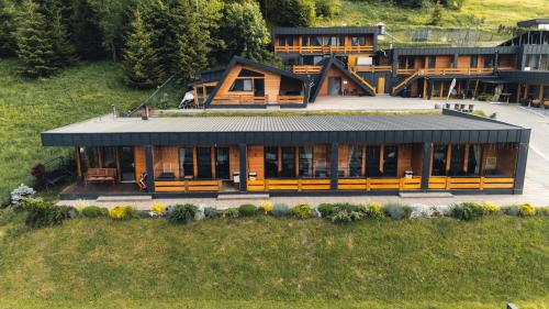a large wooden house with a lot of windows at Panoramic Residence in Borşa