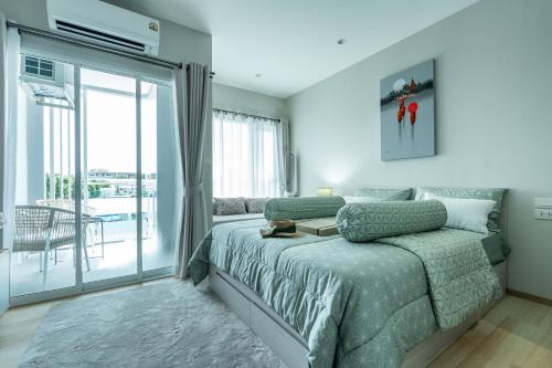 a bedroom with a bed and a sliding glass door at Serenity by Pavol in Ban Bo Han