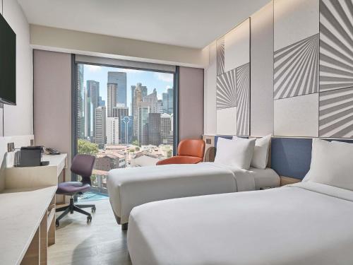a hotel room with two beds and a window at Mercure ICON Singapore City Centre in Singapore