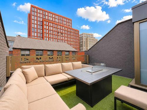 a living room with a couch and a table at Luxury Townhouse 4BR I Roof Terrace I Free Parking in Manchester