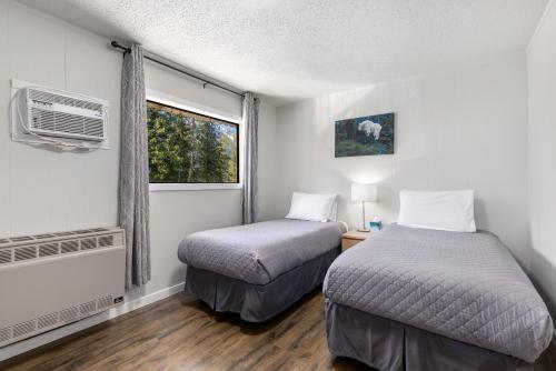 a bedroom with two beds and a window at The Hitching Post Motel in Pemberton
