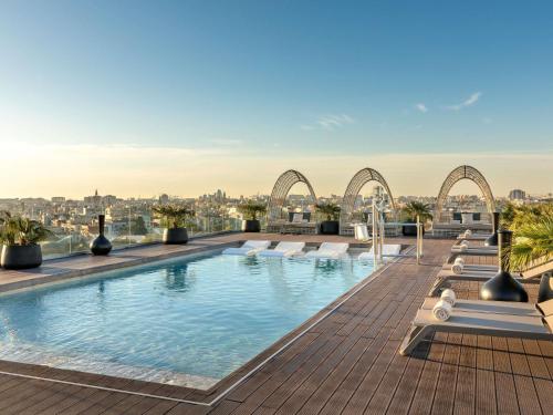 a swimming pool on the roof of a building at Novotel Valencia Lavant in Valencia