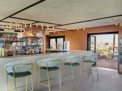 a bar with chairs and a counter in a room at Novotel Valencia Lavant in Valencia