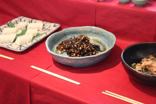 a bowl of food on a red table with chopsticks at Grand Hotel Hakusan in Hakusan