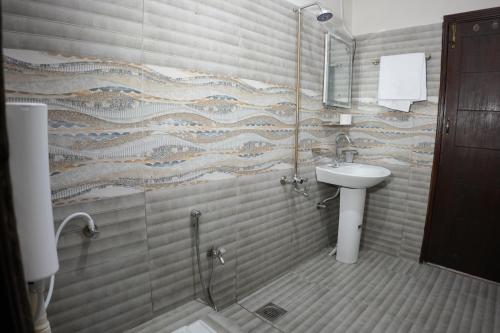 a bathroom with a glass shower and a sink at Royal Cottage in Murree in Murree