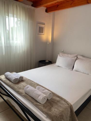 a bedroom with a large white bed with towels on it at A & D Houses No2 in Patra