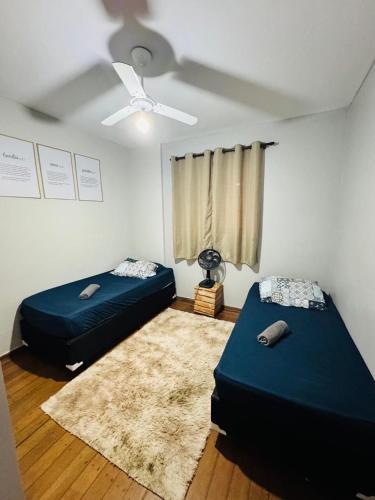 a room with two beds and a ceiling fan at Aeroporto de Guarulhos in Guarulhos