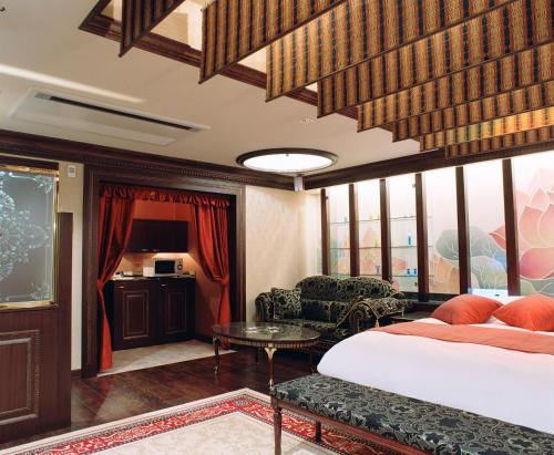 a hotel room with a bed and a table at Hotel Venus Ritz (Adult Only) in Seto