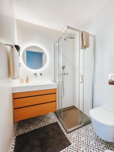 a bathroom with a shower and a sink and a mirror at Micah's Biscainhos Apartment by Quantique in Braga