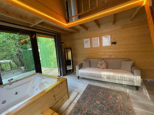 a large room with a tub and a couch at IVA House in Çamlıhemşin